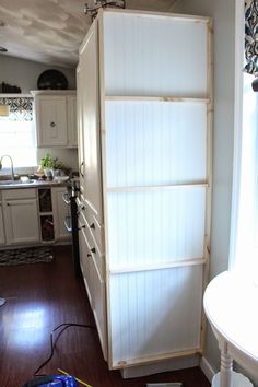 a kitchen with white cabinets and wood floors