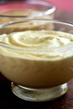 a bowl filled with cream sitting on top of a wooden table