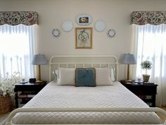 a white bed sitting in a bedroom next to two lamps on either side of it