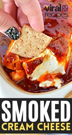 a person dipping some crackers into a bowl of food with the words smoked cream cheese