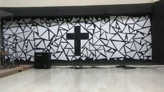 a large screen with a cross on it in the middle of a room filled with speakers