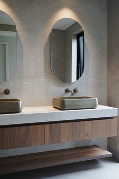 there are two sinks in the bathroom with mirrors on the wall above them and one sink below it