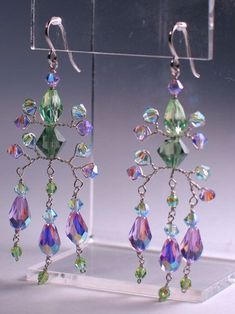 a pair of earrings with multicolored crystals