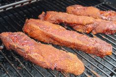 three steaks cooking on the grill with one being cooked