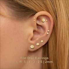 a woman's ear with gold dots on it