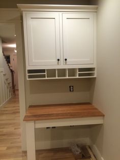 an empty room with white cabinets and wood flooring