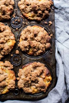 freshly baked muffins sitting in a muffin tin on top of a table