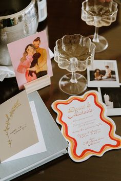 an assortment of personalized items on a table with pictures and cards in the background