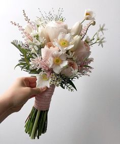 a person holding a bouquet of flowers in their hand