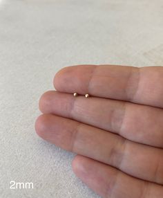 These tiny 2mm studs are made with solid 14k gold. Perfect for a minimalist look and multiple piercings. Come with the small 14k ear backs. The post length is standard at 9.5mm but can be shortened for specific needs upon request. Please allow some minimal size and shape variation, since the dots are entirely handmade. Tiny Gold Earrings, Ear Piercing Studs, Tiny Gold Studs, Lehenga Red, Second Piercing, Small Stud Earrings, Perfect Face, Pretty Jewelry Necklaces, Multiple Piercings