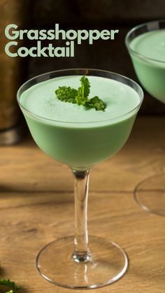 two glasses filled with green cocktail on top of a wooden table