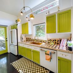 a kitchen with green cabinets and checkered flooring