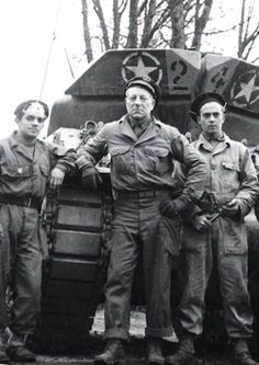 black and white photograph of men in uniform standing next to tank