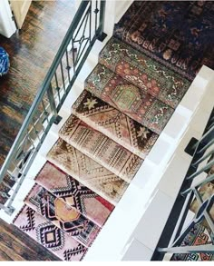 an overhead view of rugs on the stairs in a room with wooden floors and white walls