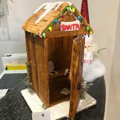 a wooden toy house with lights and decorations