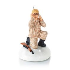 a figurine of a man sitting on top of a white base holding a cell phone to his ear