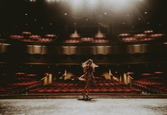 a woman standing in front of an empty auditorium