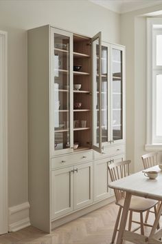 an empty dining room with white walls and wooden floors