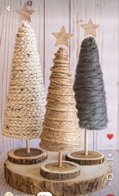 three small christmas trees on wooden stand with star decorations in the top right hand corner