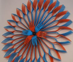 there is a blue and red fork in the shape of a sunflower on the wall