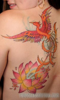 the back of a woman's body with colorful tattoos on her shoulder and chest