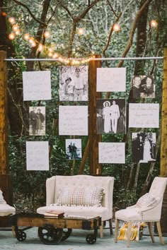 an outdoor seating area with chairs and pictures on the wall behind it, surrounded by string lights