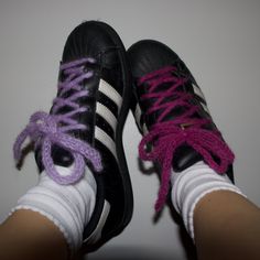 two pairs of black and white shoes with purple laces