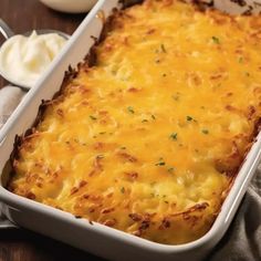 a casserole dish with cheese in it on a table next to butter and yogurt