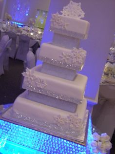 a three tiered wedding cake with snowflakes on it