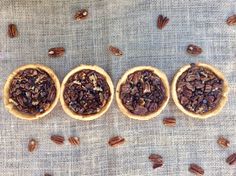 three wooden bowls filled with pecans on top of a table