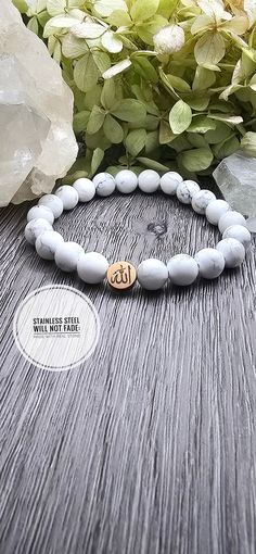 You are buying an 'Allah' bracelet complete with 8 mm white/grey Howlite stones. This can be customized in any stone and comes in an either gold or silver charm.  Howlite (Marble) Metaphysical Properties: Absorbs negative energies and calm the mind allowing for a peaceful night's rest. Pushes away overactive thoughts, anger and stress. Also works to combat your inner self critic and selfishness.  Also, for those feeling burnout from lack of sleep and bad dreams.  Charm: Stainless Steel, Laser En Ayatul Kursi Bracelet, Elegant Hand-strung Crystal Bracelet For Meditation, Muslim Faith, Spiritual Gold Crystal Bracelet, Hypoallergenic, Spiritual Hand-strung Rose Quartz Stretch Bracelet, Adjustable Rose Quartz Stretch Bracelet, Spiritual Style, Faith Bracelet, Bracelet Rose Gold, Letter Symbols