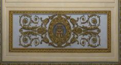 an ornate gold and white wall hanging on the side of a building