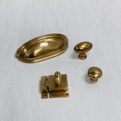 an assortment of brass hardware on a white surface