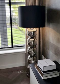 a lamp sitting on top of a table next to a window