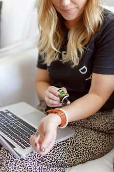 a woman sitting on a couch using a laptop computer