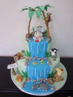 a three tiered cake decorated with animals and trees