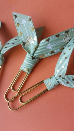 two hair clips with bows on them sitting on a pink surface next to each other