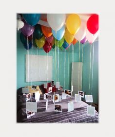 balloons are floating in the air over a table with pictures and photos on it's sides