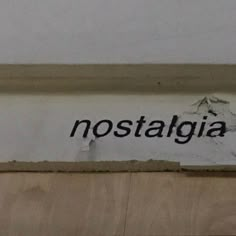 the word nostagia is written in black on a white wall