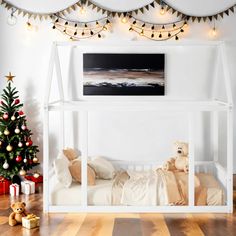 a white bunk bed sitting next to a christmas tree