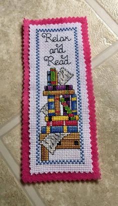 a cross - stitch bookmark with the words relax and read on it's cover