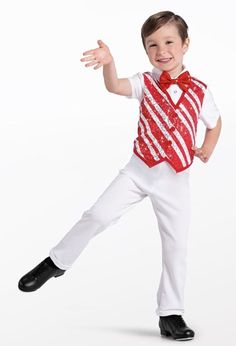 a young boy in a red vest and white pants is dancing with his arms outstretched