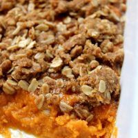 a piece of sweet potato casserole with pecans in the crust on top