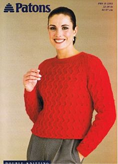 a woman wearing a red sweater and plaid pants with her hands on her hips, smiling