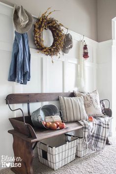 a bench that has some baskets on top of it and a wreath hanging from the wall