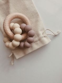 an assortment of wooden beads in a ring on a linen bag with string tied around it