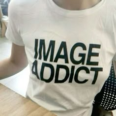 a woman wearing a white t - shirt with the words image addict printed on it