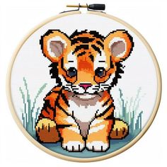 a cross stitch tiger sitting in the grass