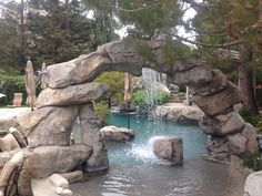 an outdoor pool with rocks and water features