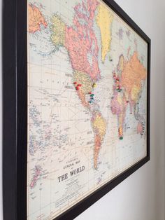 a framed world map hanging on the wall